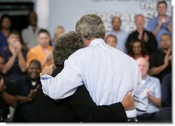 President George W. Bush hugs stage participant DeLois Killen Tuesday, May 3, 2005, at the end of a Conversation on Strengthening Social Security at the Nissan North America Manufacturing Plant in Canton, Miss. Mrs. Killen, a full-time dispatcher at the Union (Mississippi) Police Station, is not worried about losing her benefits -- which she relies on heavily -- but she believes that changes to Social Security are necessary.  White House photo by Eric Draper
