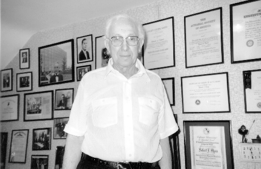 Myers in front of wall with framed photos in background