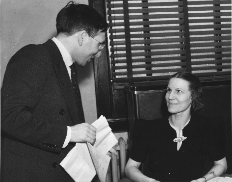 Cohen standing over Mulliner who is seated at desk