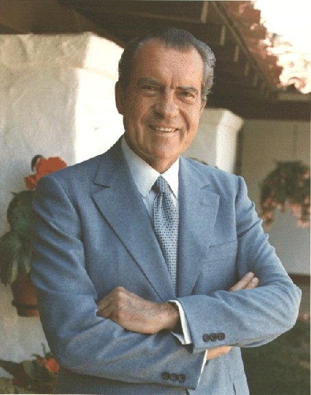Nixon in light blue suit with arms folded